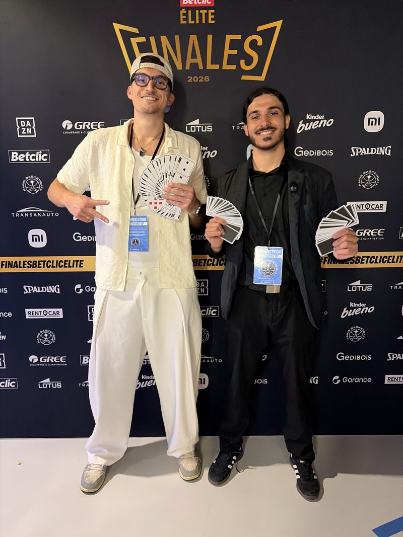 Mehdi devant le mur officiel des Finales Betclic Élite 2026, cartes en éventail